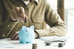 Woman hand putting coin on pig saving. Saving money wealth and financial concept, Business, finance, investment, Financial planning.
