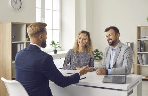 Young couple meeting with loan broker, bank manager, realtor or mortgage advisor